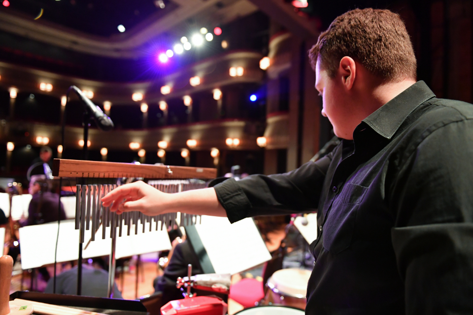 A student playing percussion in the H漫画's Jazz Orchestra in the Britten Theatre.